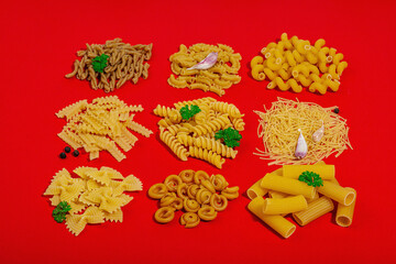 Pasta. Various kinds of uncooked pasta and noodles over wooden background
