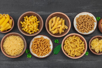 Pasta. Various kinds of uncooked pasta and noodles over wooden background. Traditional Italian