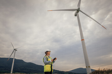 A highly skilled Wind Energy Technician diligently monitors and maintains wind turbines set in a...