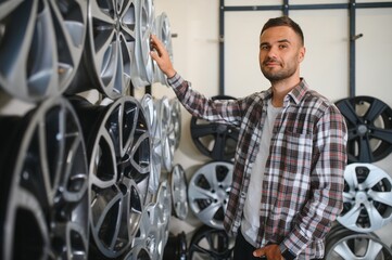 man chooses new alloy wheels in auto shop