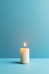 burning white candle on blue background
