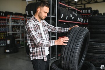 Man chooses winter car tires in the auto shop