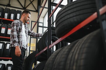Fototapeta premium Man chooses winter car tires in the auto shop