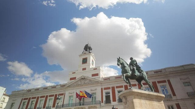 Detail shot of Casa de Correos Regional Government of Madrid (Old Post Office Building) and Carlos III Statue on a Sunny summer day blue sky and white cloud Puerta del Sol in Madrid, Spain