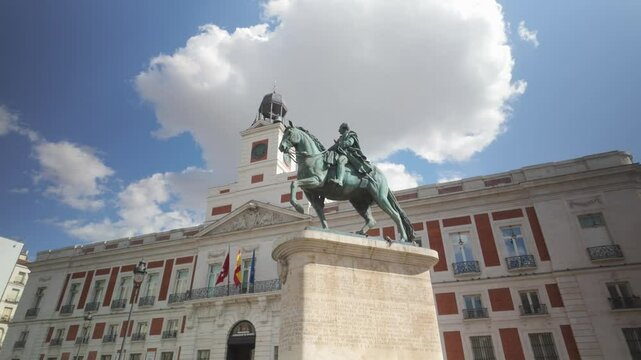 Detail shot of Casa de Correos Regional Government of Madrid (Old Post Office Building) and Carlos III Statue on a Sunny summer day blue sky and white cloud