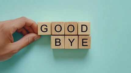 Hand pick the goodbye word wooden block on green background for farewell object.