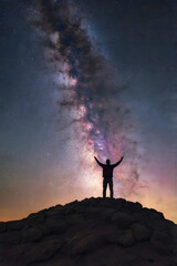 Fototapeta premium Triumphant Silhouette: Man with Arms Raised Under the Milky Way. Generative AI
