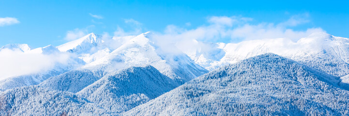 Obraz premium Mountains peaks and blue sky with clouds background