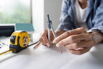 Architect Demonstrating Drafting Skills with a Compass for Building Project Layouts