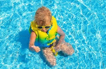 Child playing in the pool. Selective focus.