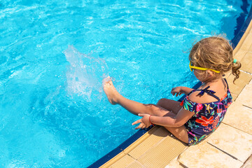 Child playing in the pool. Selective focus.