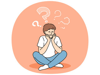 Obraz premium Thoughtful boy sits with sad face and questions above head, thinking about how to spend holidays. Teenager child is trying to remember forgotten information, or to find answers to questions.