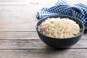 Sauerkraut in a bowl on wooden table. Traditional german food. Copy space