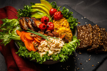 Buddha bowl with vegetables, healthy salad with avocado, carrots, corn and rice, baked chicken...