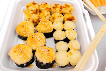 Set of fish sushi rolls with salmon,sesame in plastic disposable food container box. Seafood, Food delivery,take out service from restaurant concept.