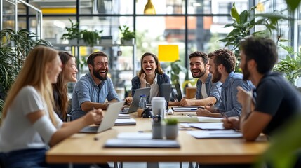Group of Young Professionals Laughing and Working Together in a Modern Office