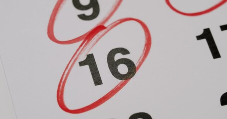 Close-up image of a calendar with the number 16 circled in red ink, highlighting an important date. Close-Up of Calendar Date, Number 16 Circled in Red Ink