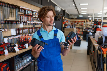 Young salesman in uniform checking laser level at hardware store