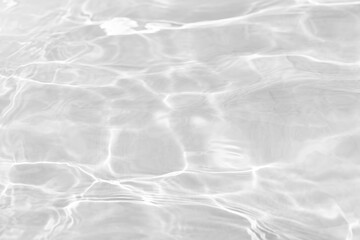 Obraz premium White water with ripples on the surface. Defocus blurred transparent white colored clear calm water surface texture with splashes and bubbles. Water waves with shining pattern texture background.