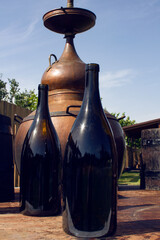 big dark wine bottles with the background of winery vat 