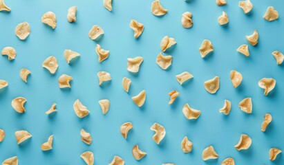 A flat lay of scattered crunchy snacks on a bright blue background, creating a fun and vibrant composition