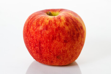 Closeup of ripe organic red apple on white table background. Selective focus.