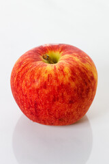 Closeup of ripe organic red apple on white table background. Selective focus.