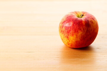 Ripe organic red apple on wooden table background.