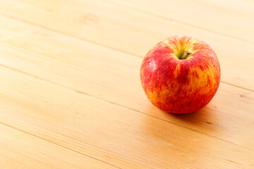 Ripe organic red apple on wooden table background.