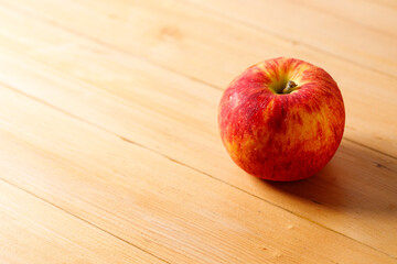 Ripe organic red apple on wooden table background.