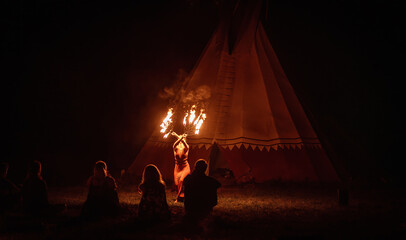 An enchanting fire dancer beautifully showcases her talent with mesmerizing flames during a performance.