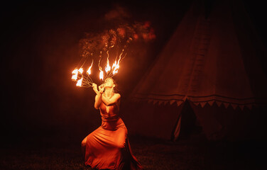 An enchanting fire dancer beautifully showcases her talent with mesmerizing flames during a performance.