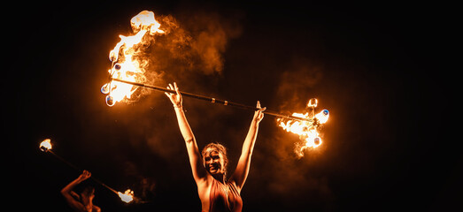 An enchanting fire dancer beautifully showcases her talent with mesmerizing flames during a performance.