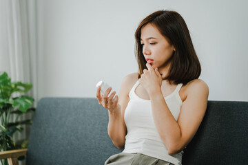 A young woman is sick and dependent on medicine. Young woman takes migraine medicine to relieve...