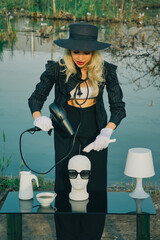 Glamorous , stylish woman cuts mannequin's head in nature. Fashion Concept, barbershop barber