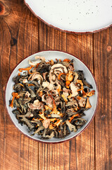 Dried mushrooms pile on rustic wooden table.