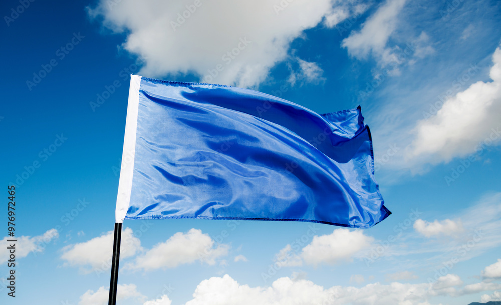 Wall mural blue flag waving on sky