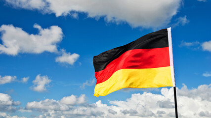 German flag waving against blue sky