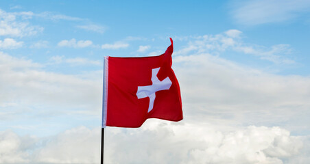 Swiss flag waving against sky