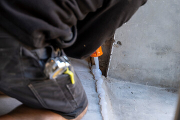 bricoleur posant de la colle ou du joins pour poser une porte sur une vieille maison