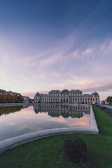 view of belvedere palace in vienna at sunset with pink clouds