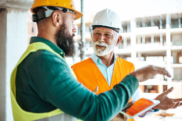 Construction Workers Discussing Project on Building Site