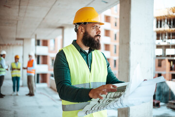 Construction Engineer Examining Blueprints on Building Site
