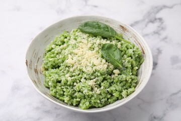 Tasty spinach risotto served on white marble table, closeup