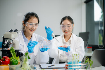 Two Asian scientists in a lab conducting food research using a microscope and lab equipment, showcasing innovation in food science