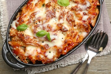 Delicious al forno pasta in baking dish on wooden table, top view