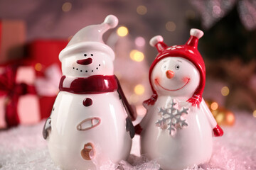 Funny snowmen figures on artificial snow, closeup