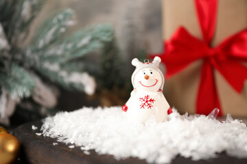 Funny snowman figure and artificial snow on table