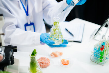 Fototapeta premium Two Asian scientists in a lab conducting food research using a microscope and lab equipment, showcasing innovation in food science
