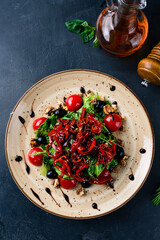 Salad with cherry tomatoes, sweet pepper, olives, walnuts, lettuce and arugula.